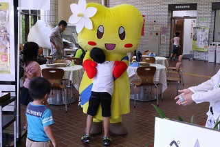 写真：歴民でおぶちゃんとハグする子どもの様子