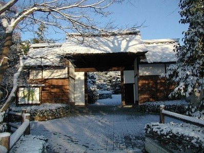 雪の日の茅葺門の写真