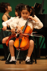 コンサートでチェロを弾く7歳当時の佐藤さん
