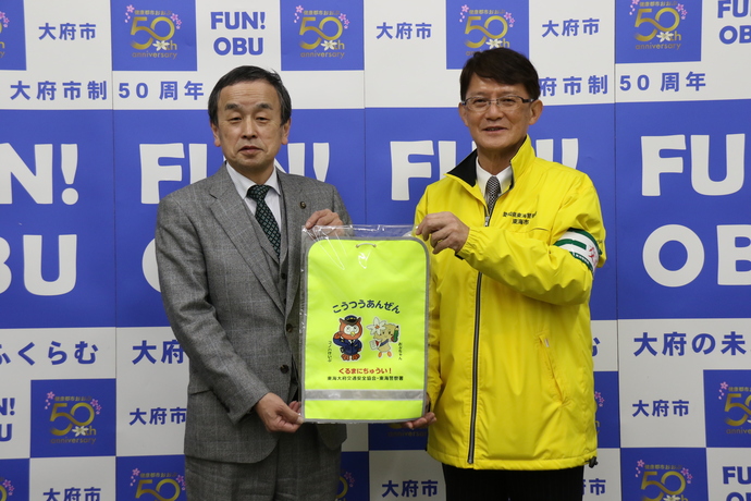 ランドセルカバーを受け取る岡村市長（写真左）