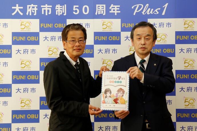 「あいち伝統野菜を学ぼう」学習ノートを受け取る岡村市長（写真右）
