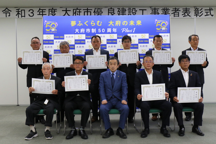優良建設工事業者表彰式で表彰者と記念撮影をする市長
