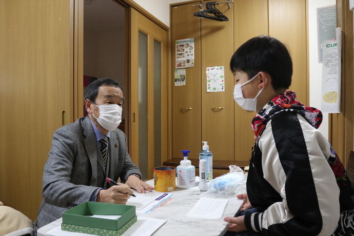 受け付けをする岡村市長と子ども