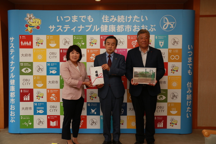 藤下理恵子常務取締役（左）と片貝義明矢場とんブースターズ総監督（右）と岡村市長（中）