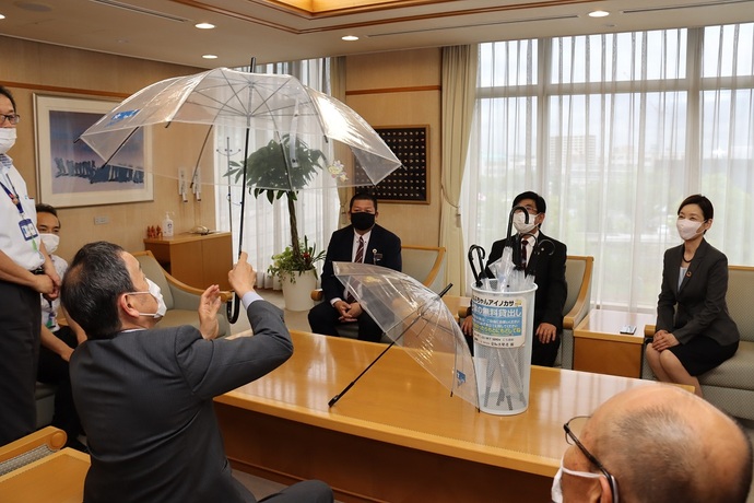 寄付された傘を持つ岡村市長