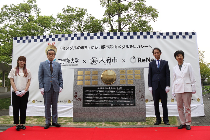記念碑の前で記念撮影する岡村市長や吉田沙保里ら