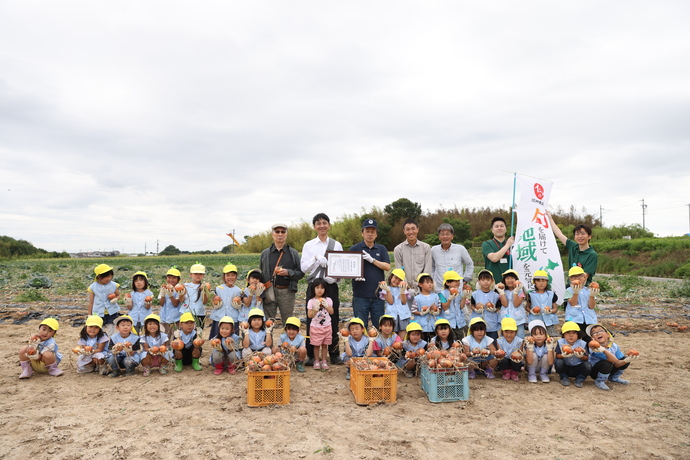 収穫体験をした子供たちと岡村市長の集合写真