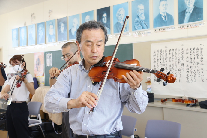 市長がバイオリンを弾く写真
